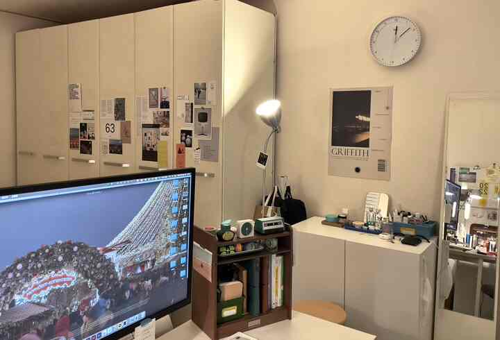 ベージュの壁と白いクローゼットが配置された一人暮らしの寝室、化粧台の棚とフロアランプが調和した落ち着いた空間