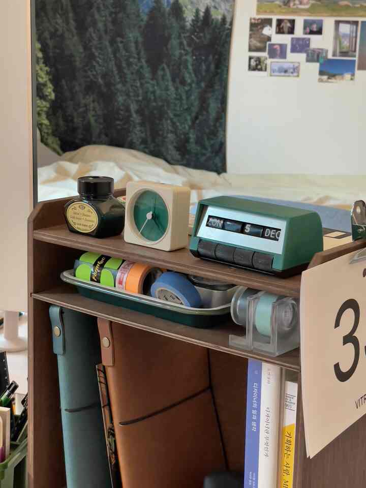 白い壁と木目調の棚が配置されたホームオフィス空間、整頓されたオブジェと文房具が置かれた雰囲気のあるインテリア