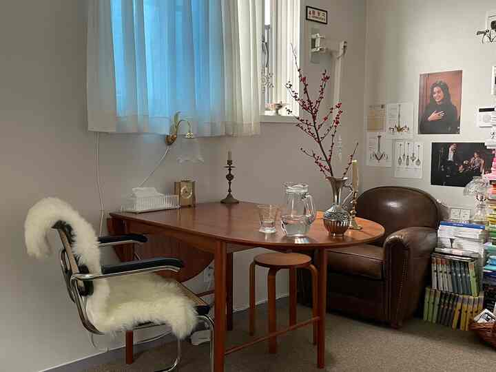 ブラウンとナチュラルトーンの二人用ダイニングルーム、木製テーブルとレザーアームチェアが配置された雰囲気のある空間