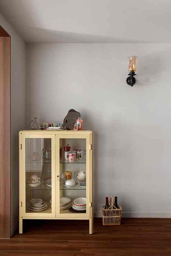 黄色の収納キャビネットが配置されたグレーの壁と木目調の床の、雰囲気のある空間