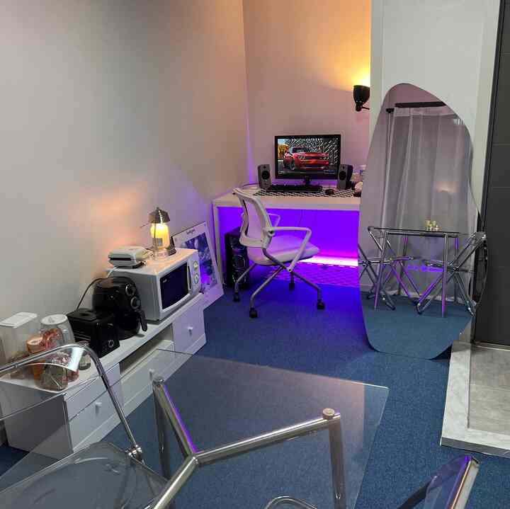 ホワイトとブルーのトーンのパソコン作業スペースとキッチン家電が配置された清潔感のあるホームオフィス