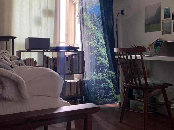 白と木目調のワンルーム書斎、ベッドと木製デスク、書棚が配置された雰囲気のあるヴィンテージインテリア