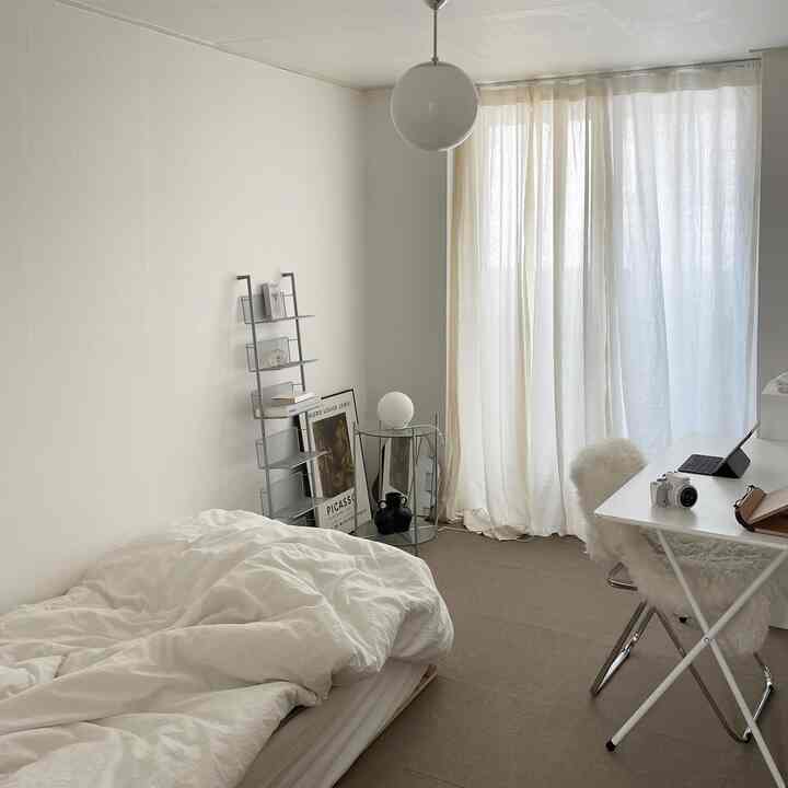 白を基調とした寝室、シンプルな家具が配置された暖かい雰囲気の空間