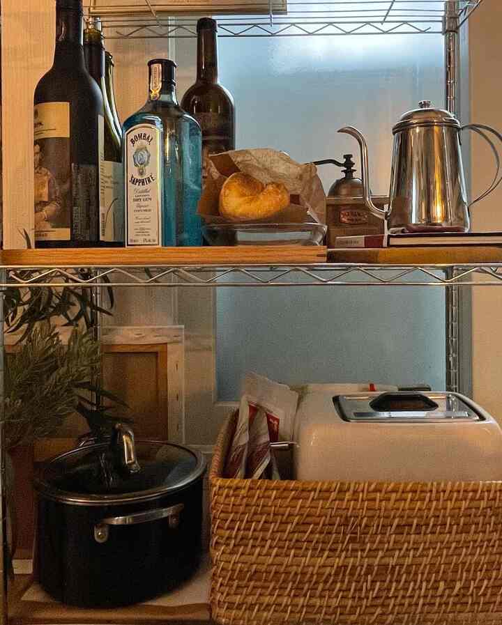 シルバーのステンレス棚とブラウンのラタンバスケットがあるキッチン空間、コーヒーマシンや器具が並ぶ温かみのあるおうちカフェ