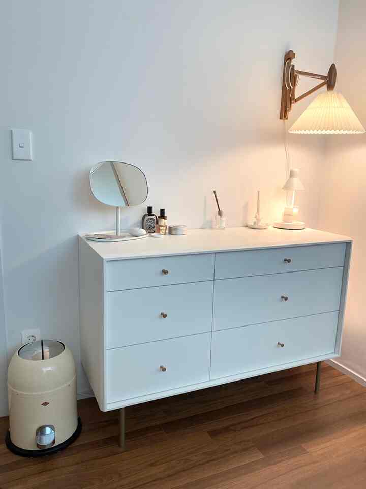 ホワイトトーンのウォークインクローゼット、化粧台と鏡、壁掛け照明が配置された清潔感のある空間