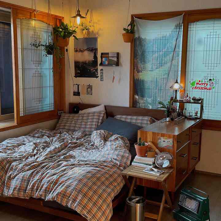 ナチュラルカラーと木目調の寝室、木製ベッドとナイトテーブルに植物が配置された雰囲気のある空間