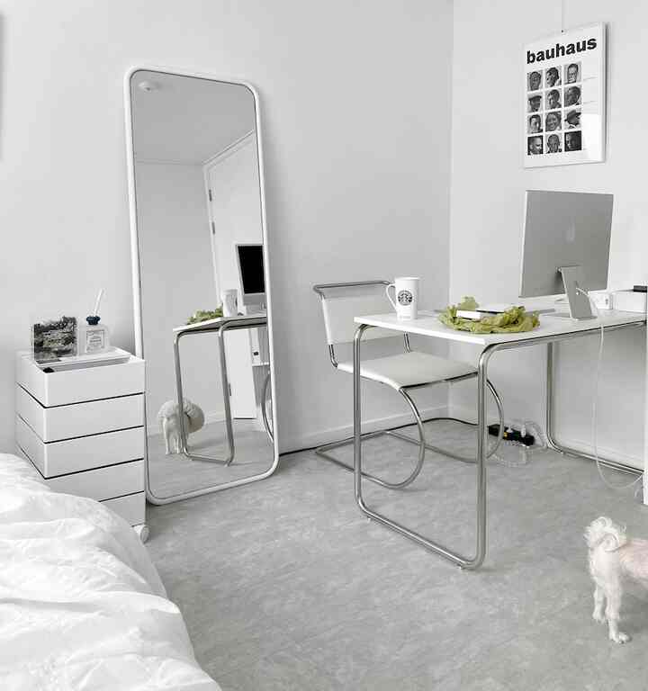 白とシルバーのトーンのミニマルなホームオフィス、シンプルなデスクと椅子が配置されたモダンな雰囲気のあるインテリア