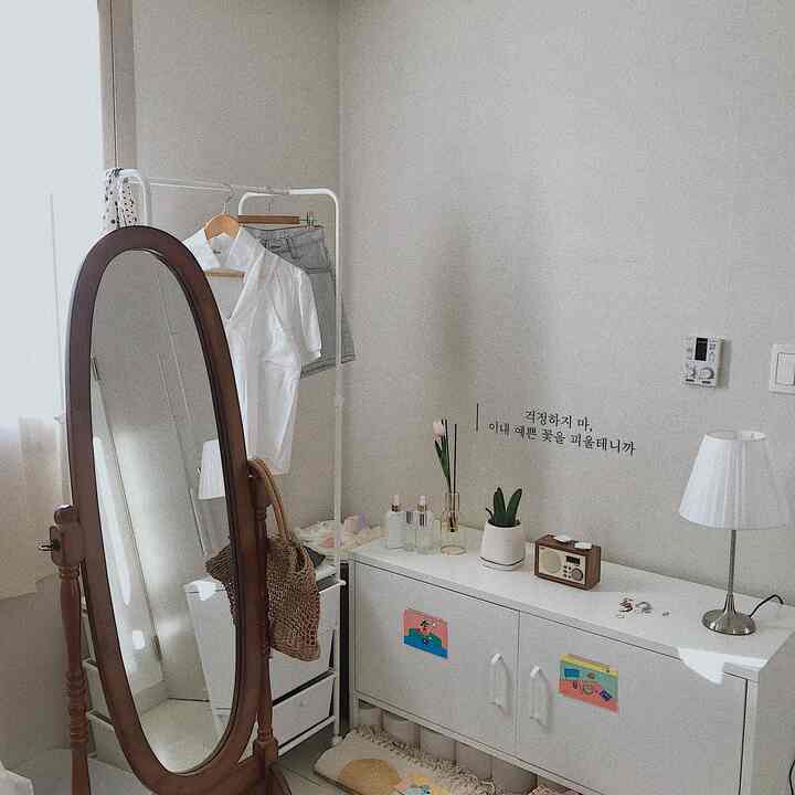 白と茶色のトーンの狭い部屋、全身鏡と白いキャビネットが配置された自然な雰囲気のインテリア