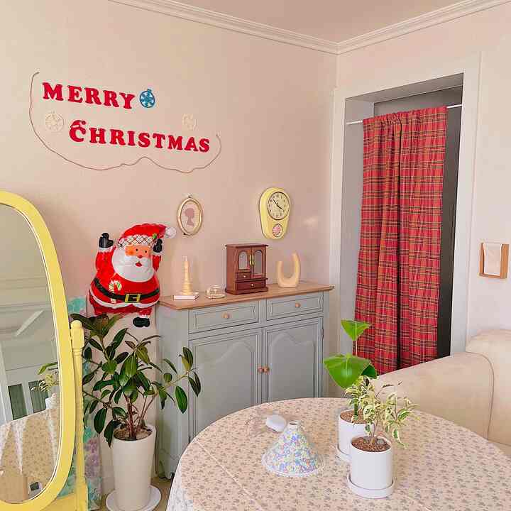 アイボリーとレッドの色調のリビング、コンソールテーブルとチェック柄カーテン、クリスマス飾りが配置された居心地の良いインテリア