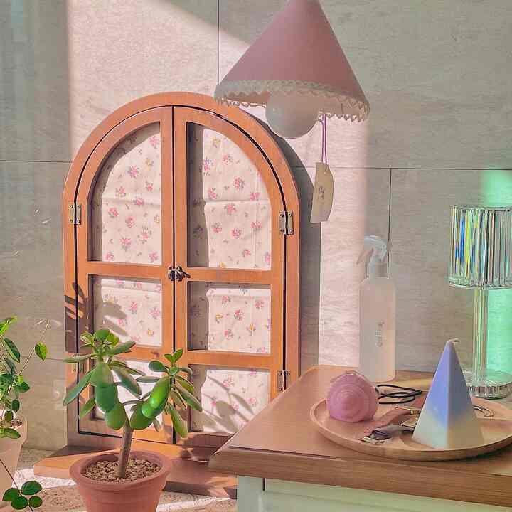 ナチュラルな色調の小さな空間、木製の収納棚と植物が配置された温かみのあるインテリア