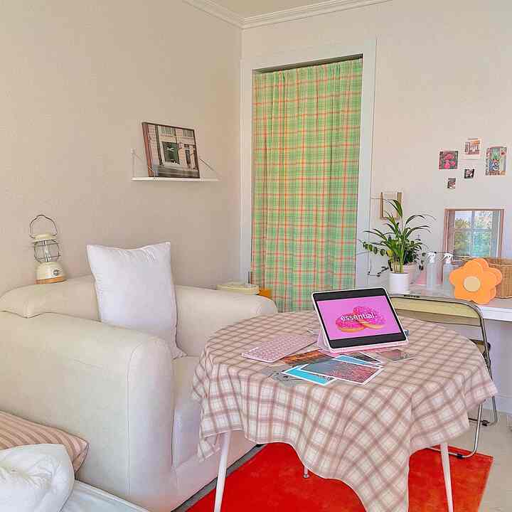 クリーム色のソファとチェックのテーブルクロスがあるナチュラルなダイニングルーム、シンプルで清潔感のあるホームオフィス空間