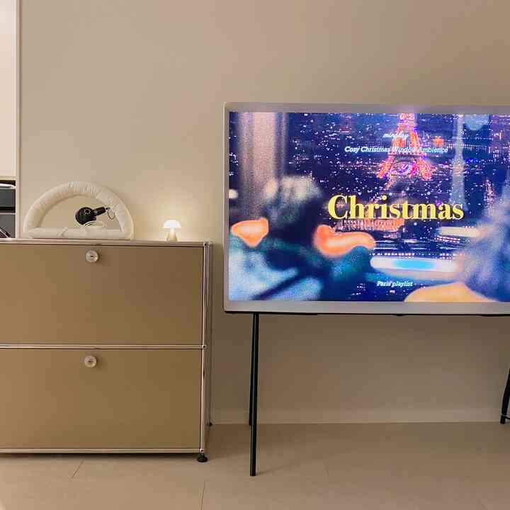 白とベージュのトーンのリビング、ミニマルなテレビ台とチェストが配置された清潔感ある空間