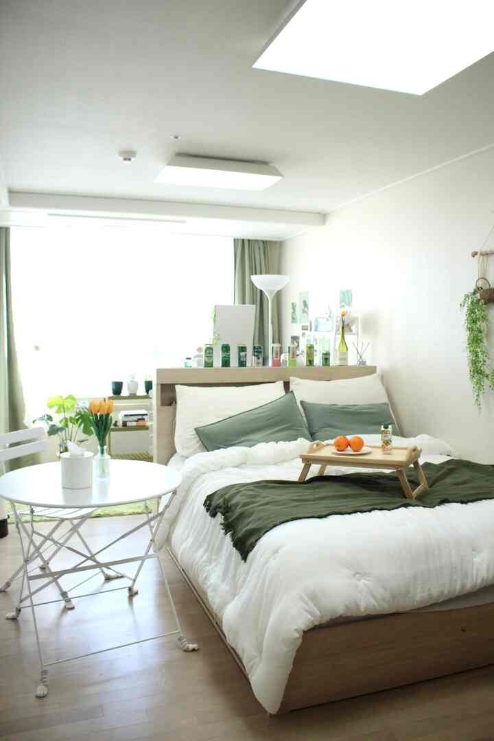 白と木目調、緑が調和したワンルームの寝室、暖かくて自然な雰囲気のあるインテリア