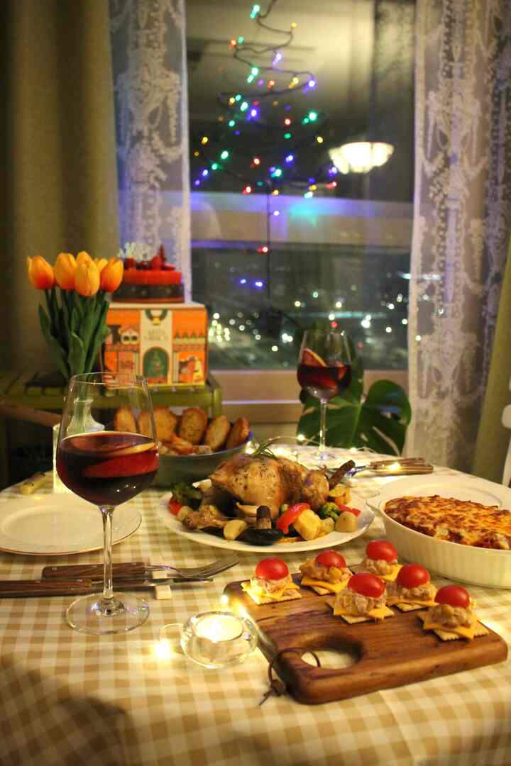 暖かいベージュチェックのダイニングテーブルに赤いワイングラスが並ぶ窓辺のホームパーティースペース