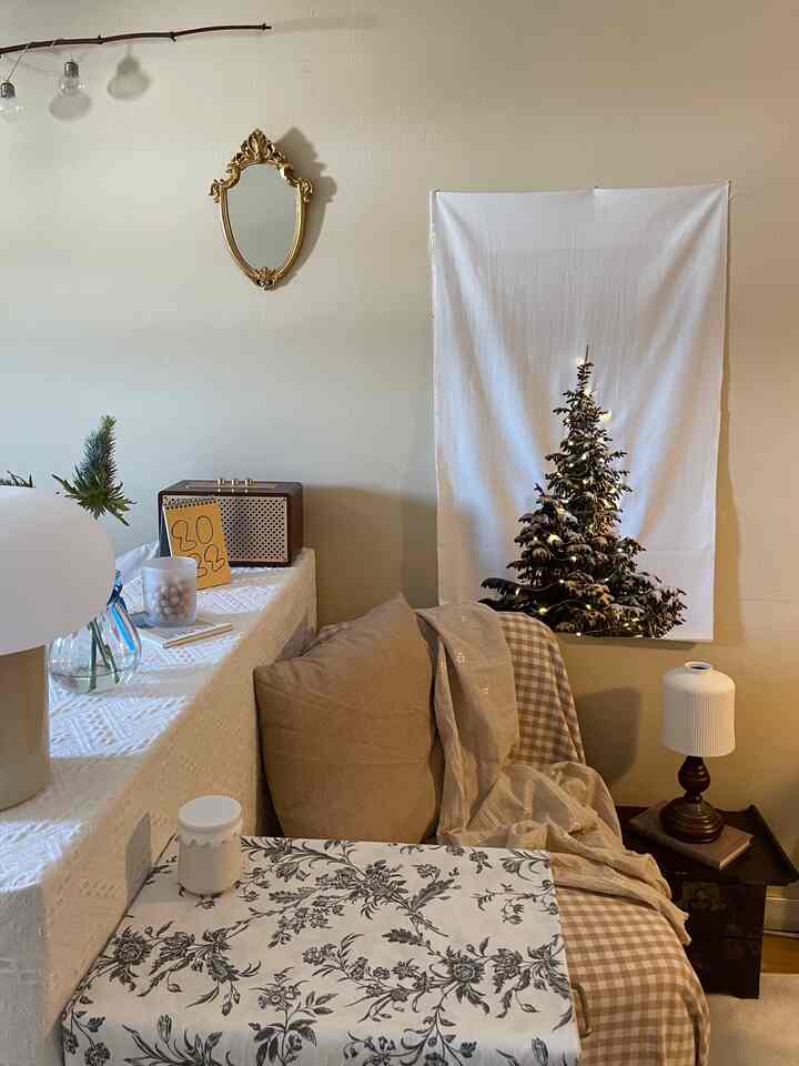 ブラウンとホワイトの色調のリビング、ヴィンテージの鏡とソファ、小さなテーブル、テーブルランプが配置された雰囲気のあるインテリア