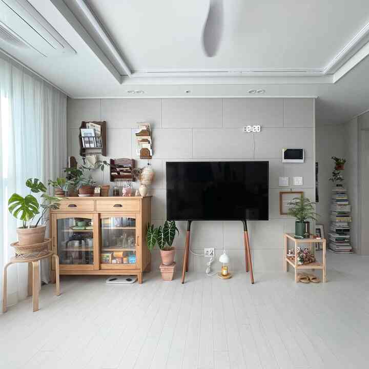 白い背景に木目調の家具とヴィンテージの小物が配置された明るく落ち着いたリビングスペース