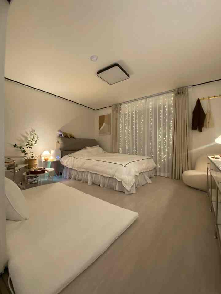 明るいホワイトとベージュの色調の寝室、ベッドと布団が広々と配置されシンプルで自然な雰囲気のインテリア