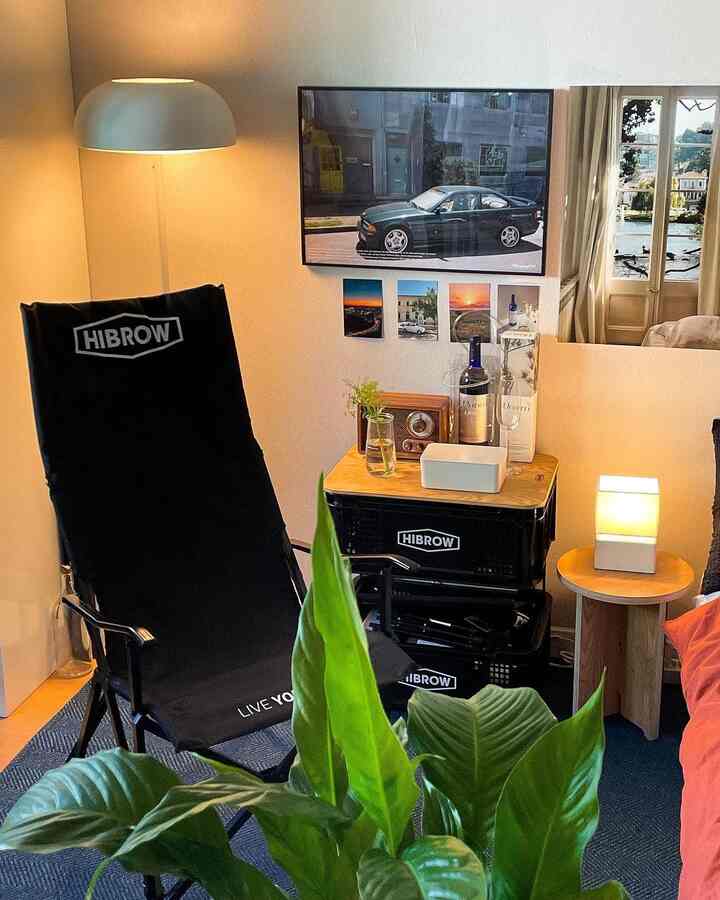 ネイビーのラグとハイブロウのキャンプチェアが置かれた居心地の良い一人暮らし用リビング