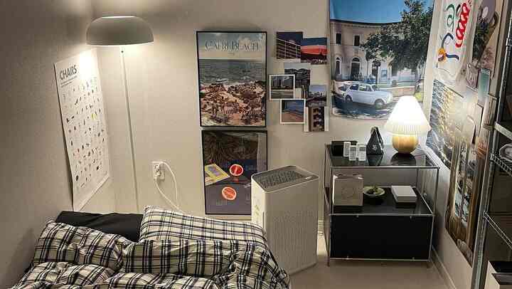 アイボリー調の小さな寝室、チェック柄の寝具とポスターデコレーションが配されたシンプルモダンな雰囲気のインテリア