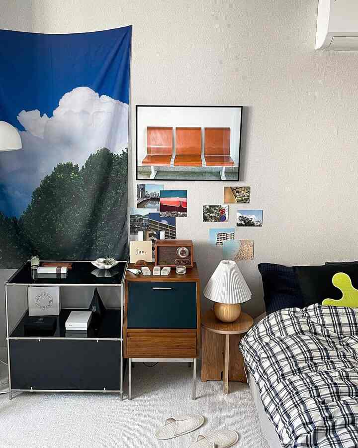 青いファブリックの壁掛けとブラウンの木目調家具がある一人暮らしの寝室、モダンでナチュラルな雰囲気の清潔感ある空間