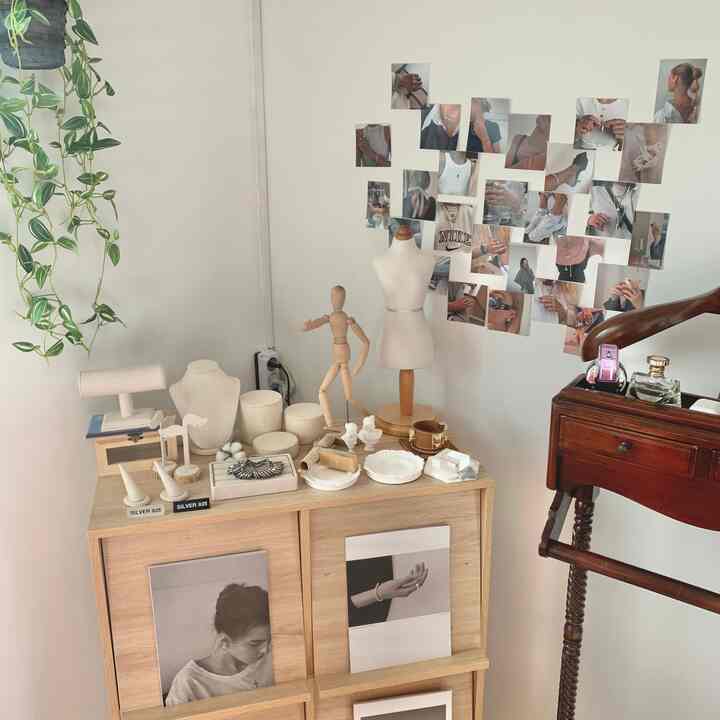 ナチュラルな色調の空間、木製家具とマネキン、フォトコラージュが配置された雰囲気のあるインテリア