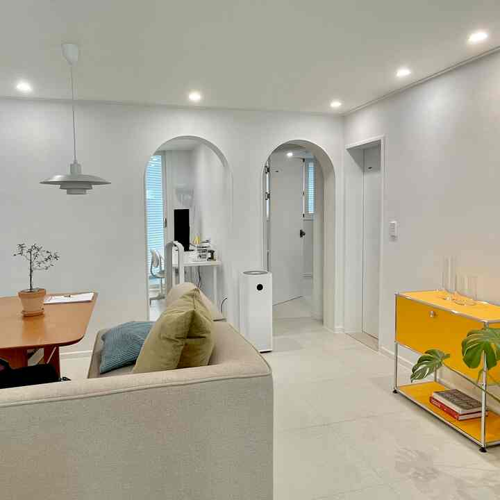 ホワイトトーンのリビング・ダイニング、アーチ型の開口部とモジュール家具が配置されたモダンで清潔感のあるインテリア