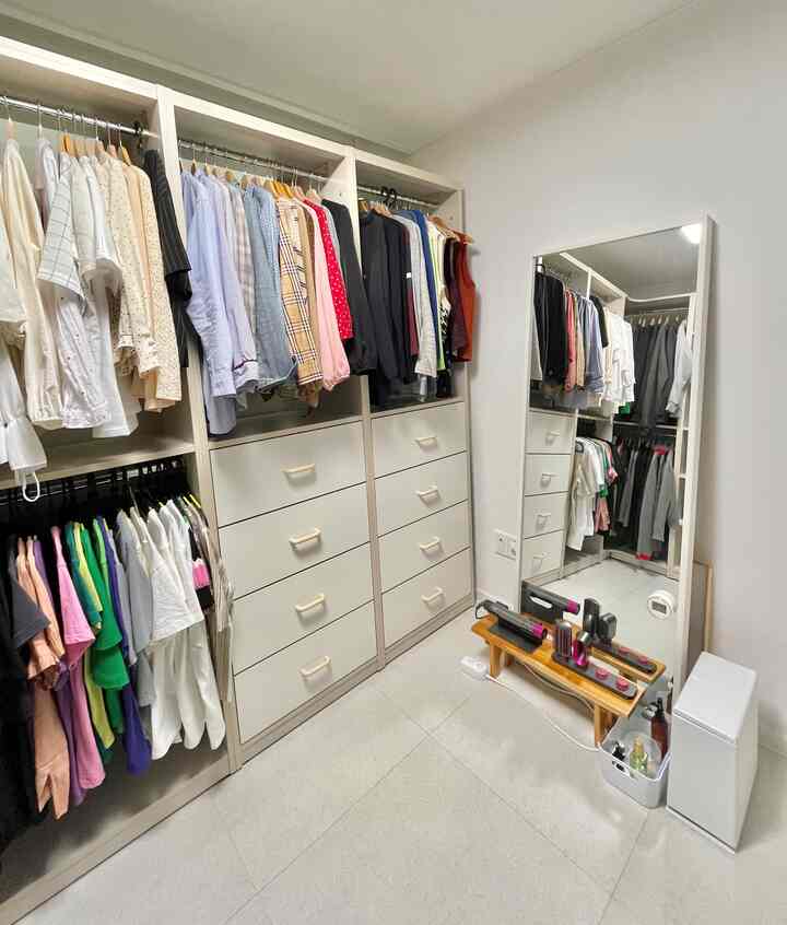 ホワイトとベージュの色調のウォークインクローゼット、大きな全身鏡とモジュール家具が整然と配置された印象的な空間