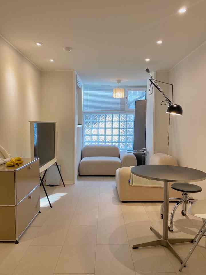 明るいホワイトとベージュのトーンのリビング、シンプルなソファとコーヒーテーブルが配置されたモダンでナチュラルな雰囲気のインテリア