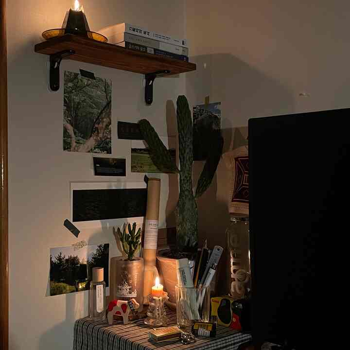 暖かいブラウンとナチュラルカラーの一人暮らし用ホームオフィス、様々なオブジェとキャンドルが配置された雰囲気ある空間