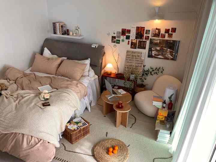 ベージュとブラウンのトーンのワンルーム寝室、ふんわりしたホテル風寝具と木製家具が調和した温かみのあるインテリア