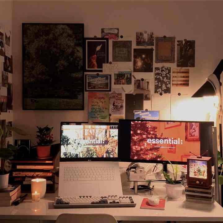 温かみのあるブラウンとホワイトのトーンが特徴的な一人暮らしのホームオフィス、モニタースタンドやキャンドルが置かれた居心地の良い作業空間