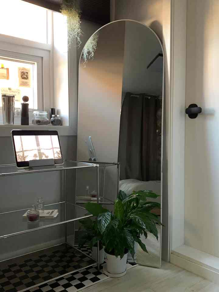 ブラックとホワイトのトーンの寝室、装飾キャビネットと全身鏡が配置されたモダンで落ち着いたインテリア