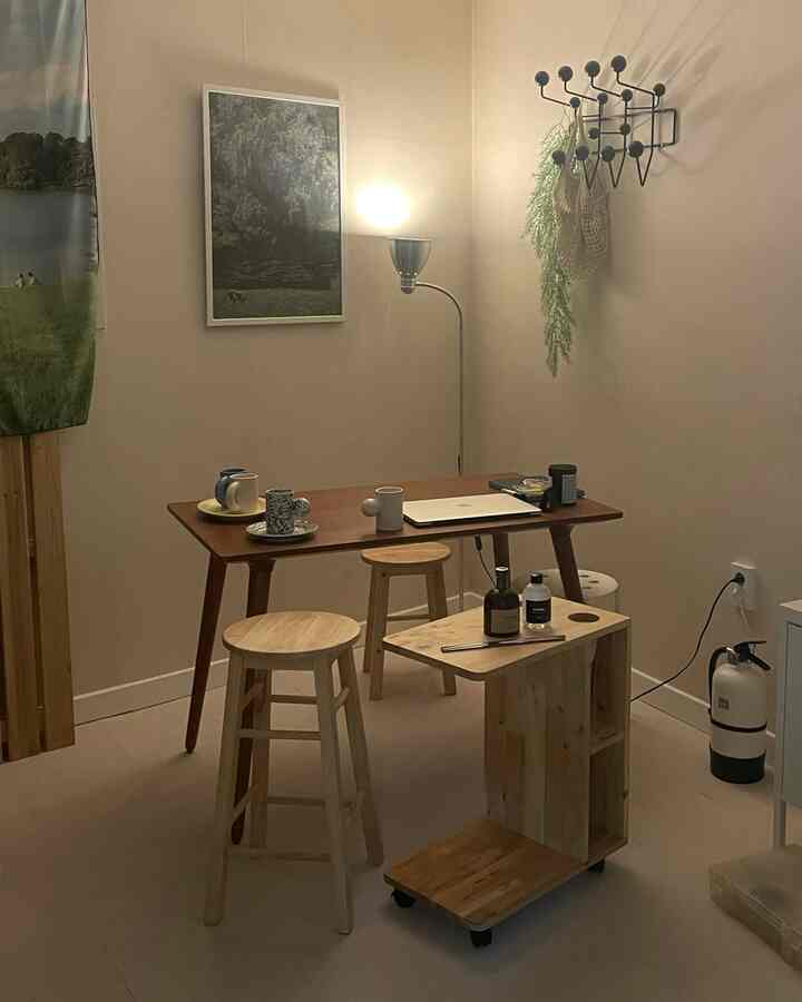 ベージュの壁と木目調の家具が配置されたワンルームのホームオフィス、素朴で温かみのある雰囲気