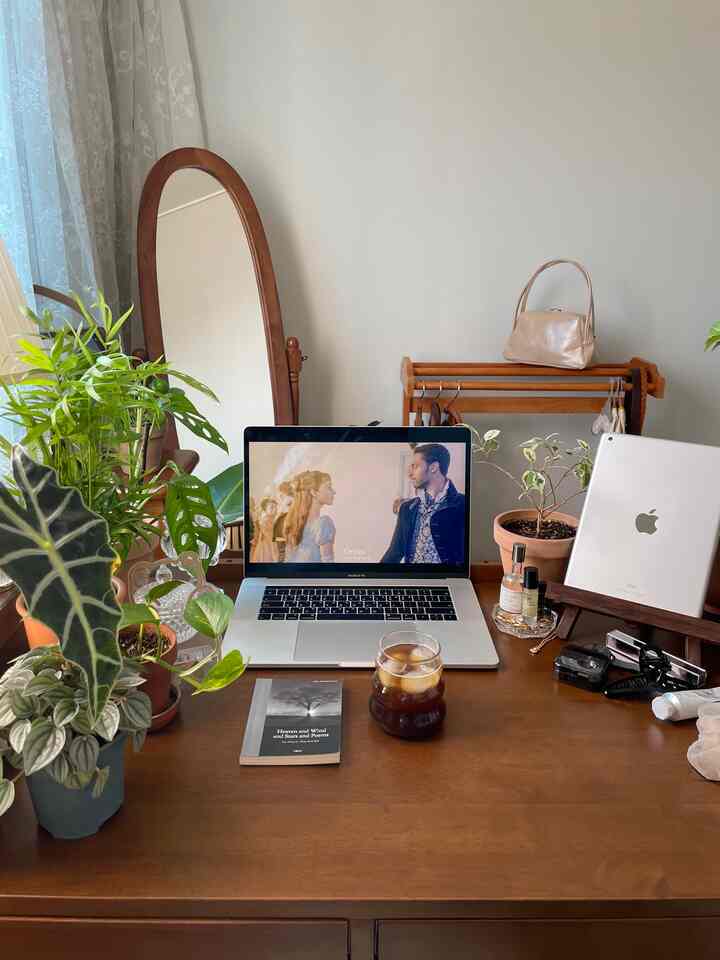 温かみのある木目調のホームオフィス兼ホームカフェ空間、ノートパソコンと植物が置かれた整頓されたデスクと全身鏡が配された雰囲気のあるインテリア