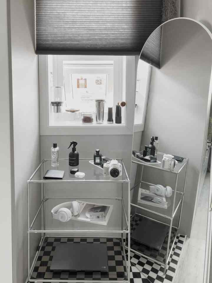 グレー調のコンパクトな玄関スペースにモジュール家具と全身鏡、ブラインドが配置されたミニマリストなインテリア