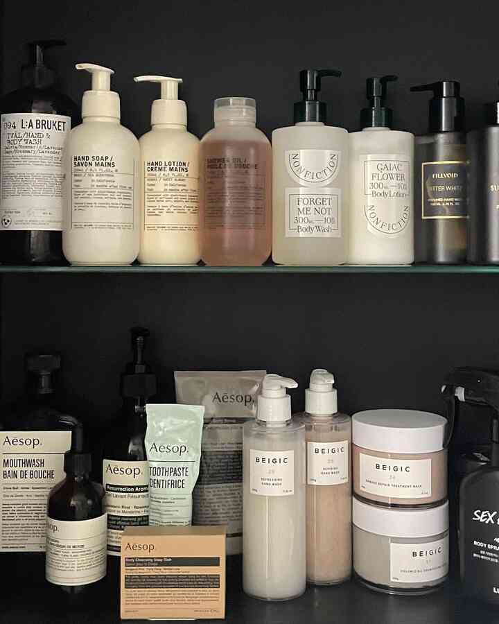 白と黒のトーンでまとめられたバスルームの棚、多様なコスメ製品が整然と並ぶ雰囲気のあるインテリア