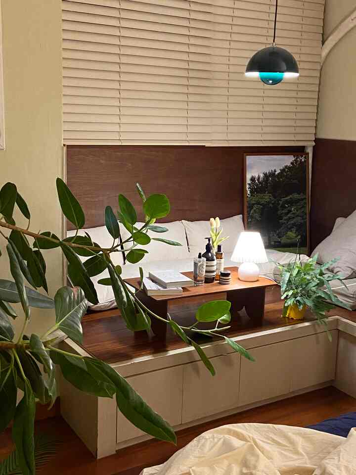 ベージュと木目調のリビング、ソファとコーヒーテーブル、植物が配置されて自然で落ち着いた雰囲気のインテリア