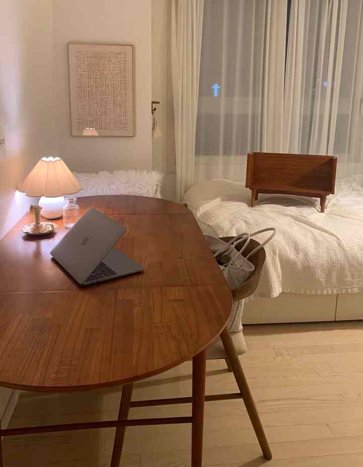 ナチュラルカラーとモノトーンの6畳寝室、木製デスクとスタンド照明が配置された雰囲気のあるホームオフィス空間