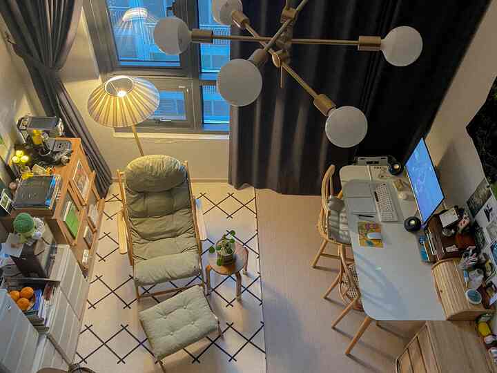 落ち着いたブラウンとホワイトの色調の1階作業スペース、リクライナーやデスク、ラグが配置された居心地の良いホームオフィス