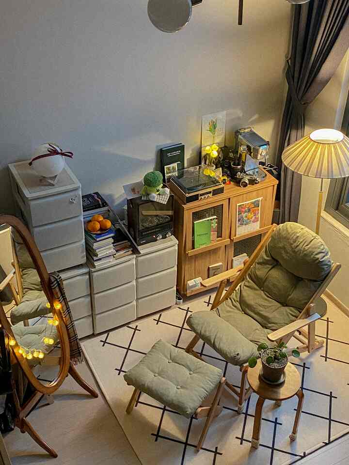 ナチュラルな色調のワンルームリビング、ナチュラルクッションのアームチェアとパターンラグが配置された雰囲気のあるヴィンテージ空間