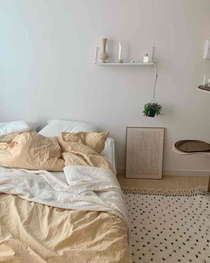 ベージュと白の色調の寝室、快適なベッドとシンプルでナチュラルなインテリアが配置された落ち着いた空間