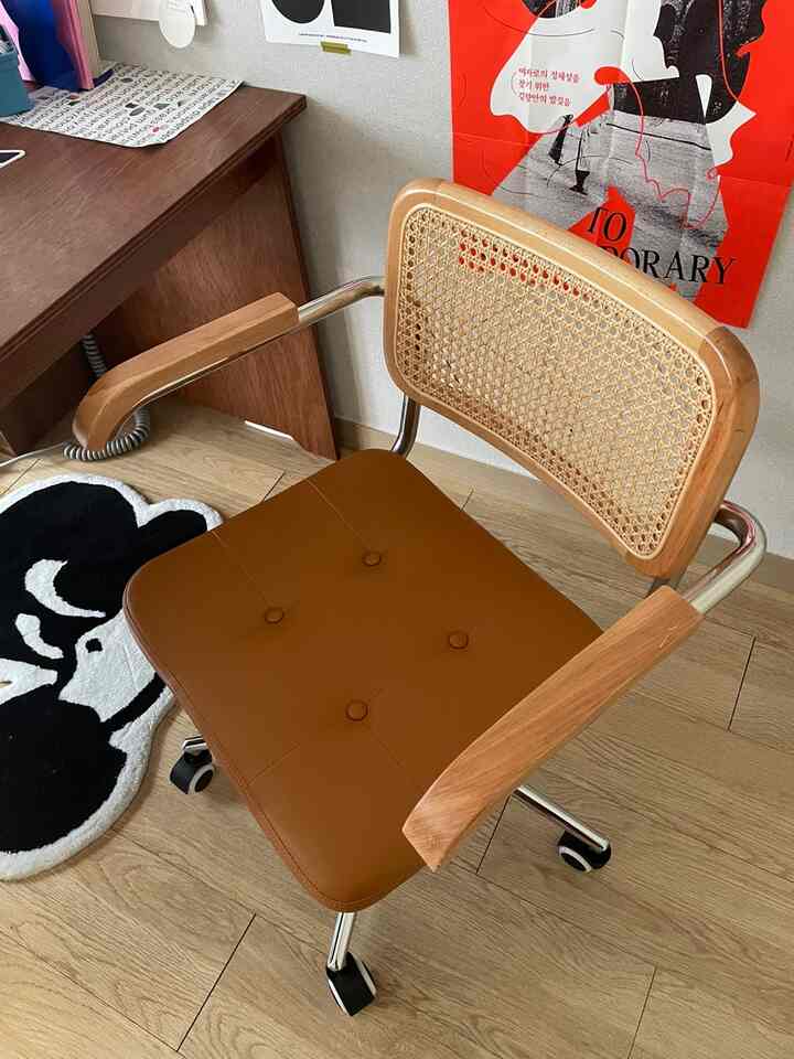 ナチュラルな木目調とブラウンのレザーを組み合わせたホームオフィス用のオフィスチェアとデスクが配置された空間