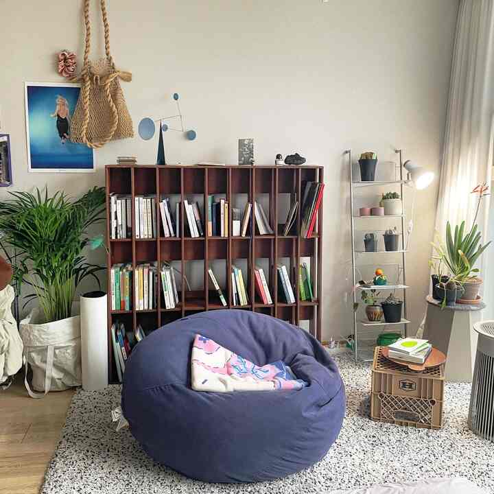 ナチュラルな色調のリビング、ビーンバッグと木製の本棚が配置された雰囲気のある空間