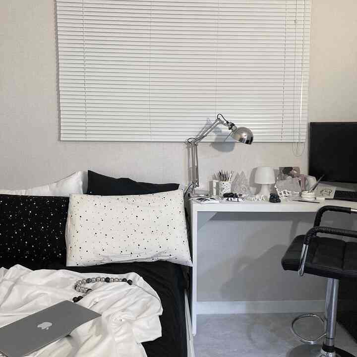 ホワイトとブラックのトーンでまとめられた6畳の寝室、コンパクトなデスクとオフィスチェアが配置されたモダンなホームオフィス空間