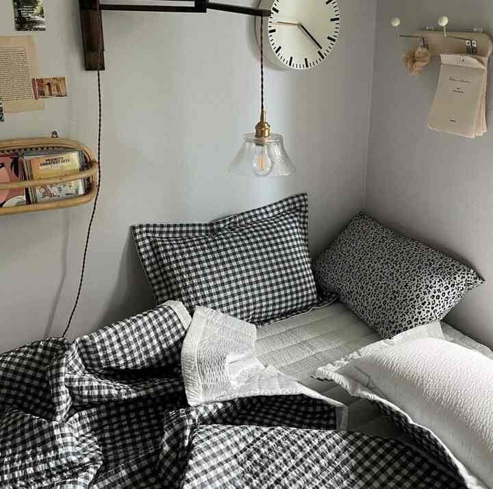 白と黒のチェック柄寝具が配置された、落ち着いた雰囲気の寝室のコーナー