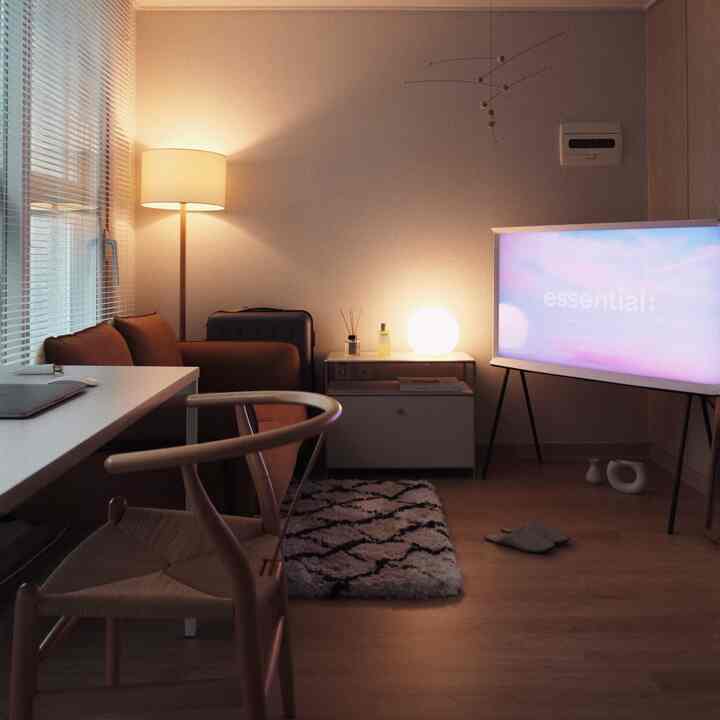 ベージュとブラウンの色調の落ち着いた一人暮らし用ホームオフィス、ソファやデスク、フロアランプ、ミニラグが配置されたシンプルモダンな空間