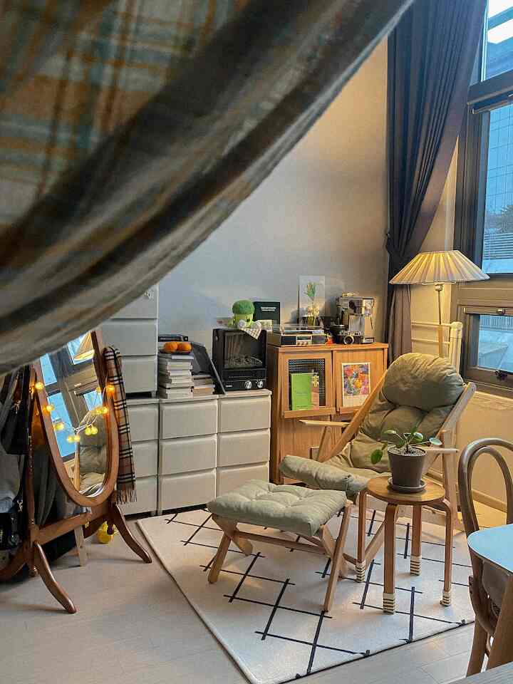 ウッドトーンとホワイトが調和した小さなリビング空間、リクライニングチェアとフロアランプ、整頓された収納が映える居心地の良いおうちカフェインテリア