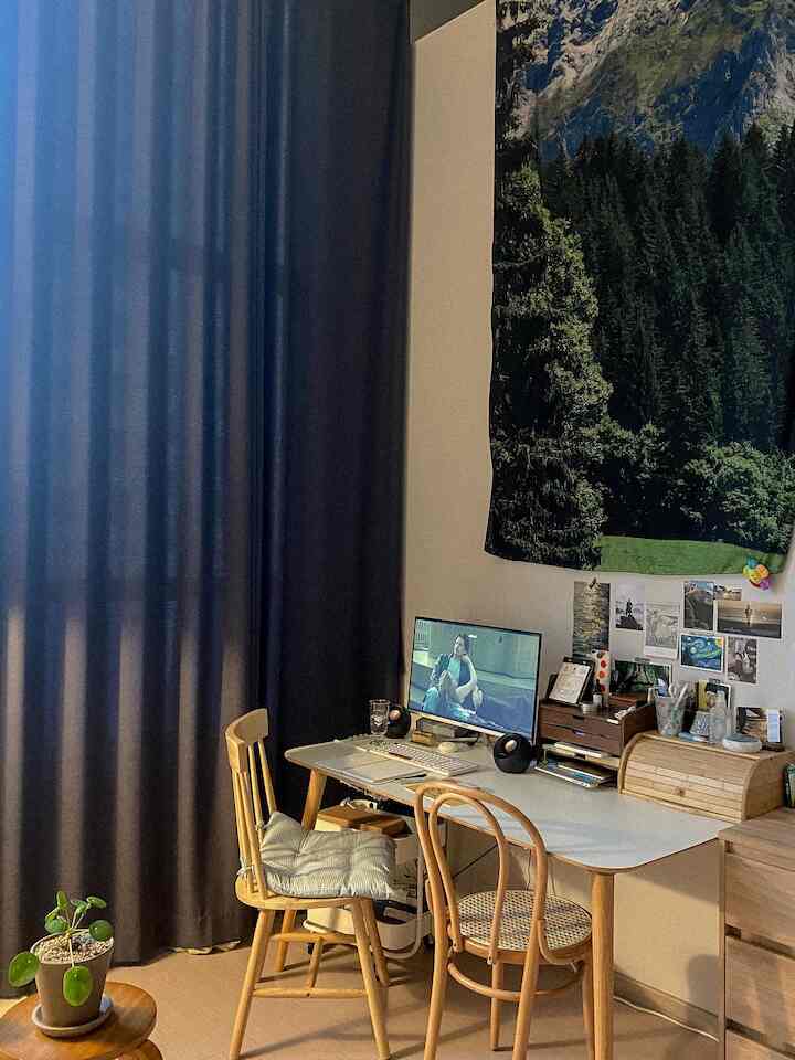 ネイビーカーテンとホワイトのデスク、木製のチェアが配置された居心地の良いホームオフィス空間