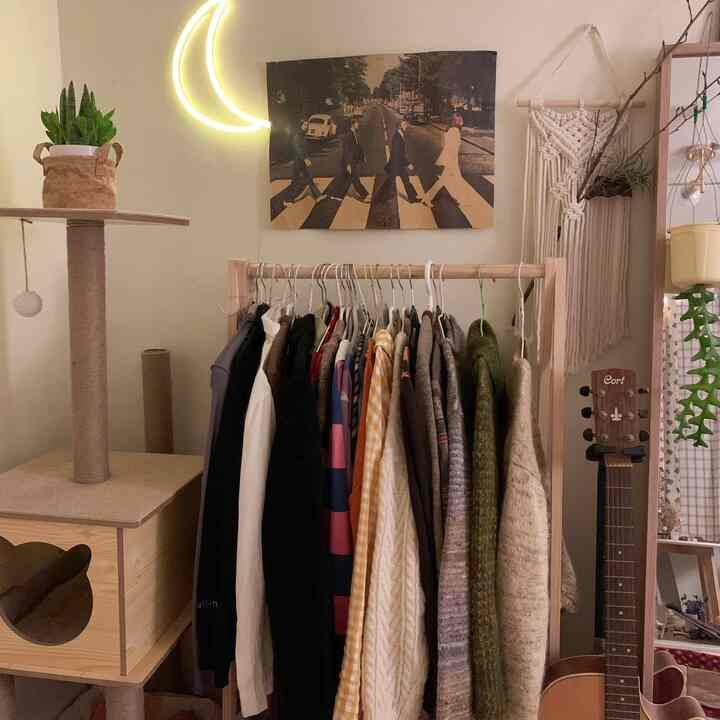 木目調の温かみあるトーンとナチュラルな素材が映える部屋、キャットタワーとオープンクローゼット、ビートルズのポスターが配された印象的な空間