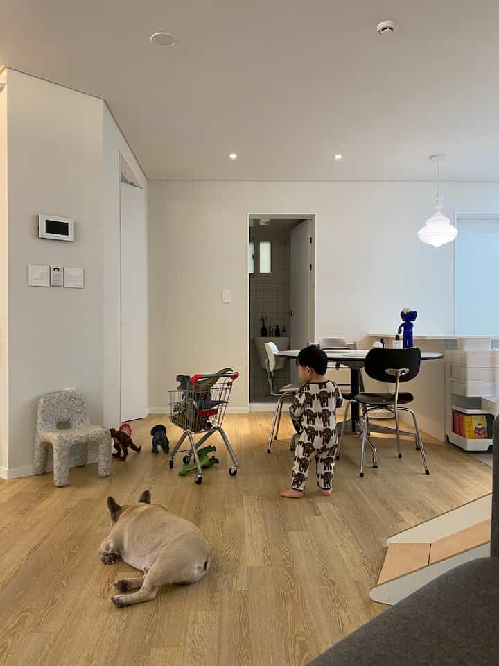 ナチュラルカラーのリビング、子供とペットの犬がいる居心地の良く少し散らかった雰囲気のインテリア